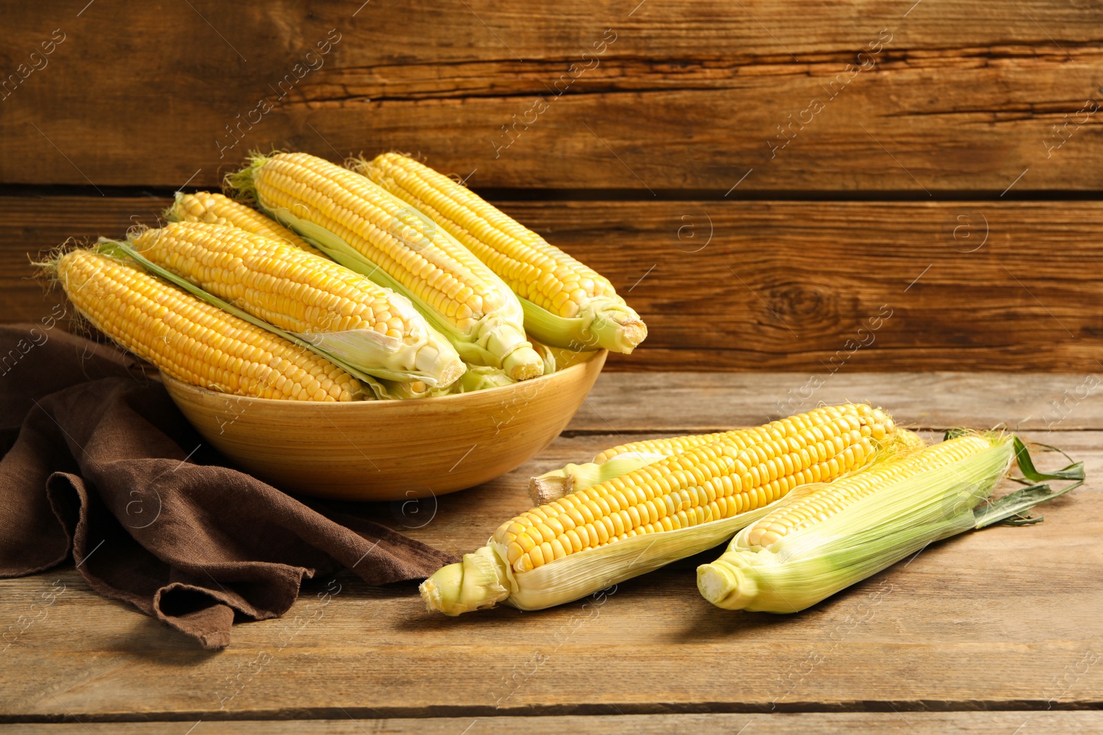 Photo of Tasty sweet corn cobs on wooden table