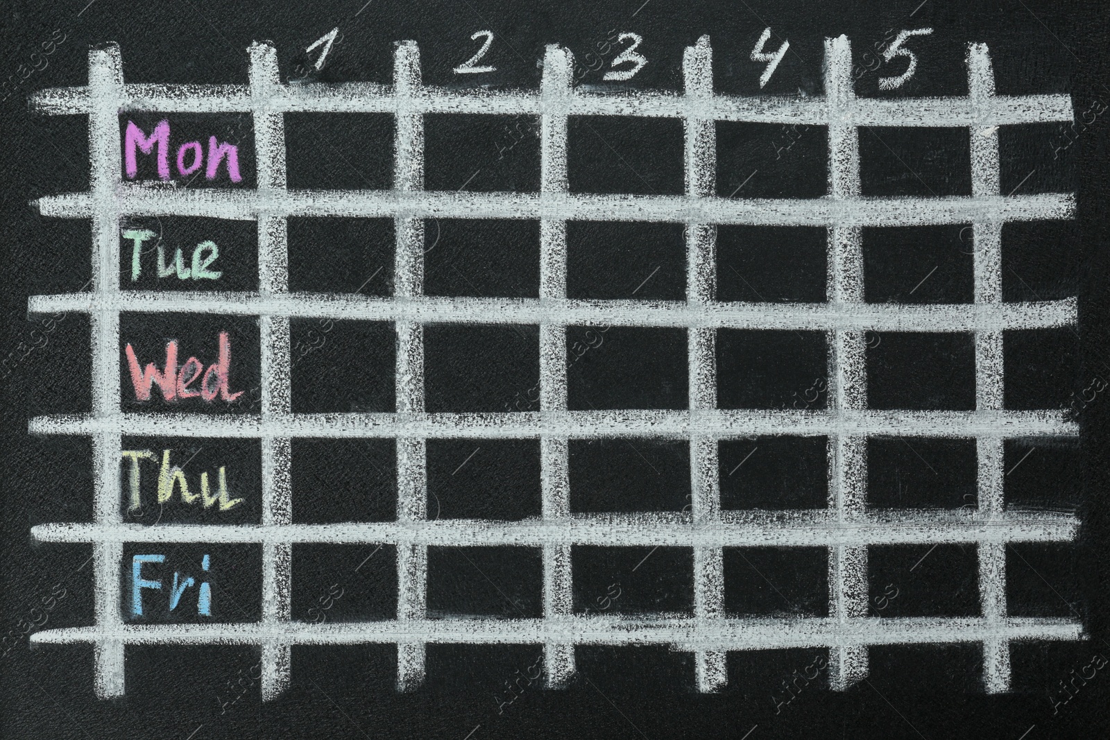 Photo of Weekly school timetable drawn on black chalkboard