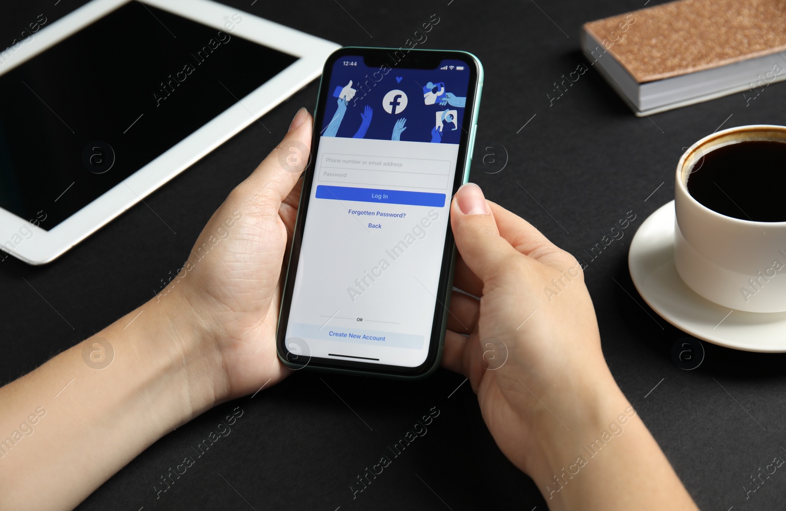 Photo of MYKOLAIV, UKRAINE - JULY 9, 2020: Woman holding Iphone 11 with Facebook app on screen at black table, closeup