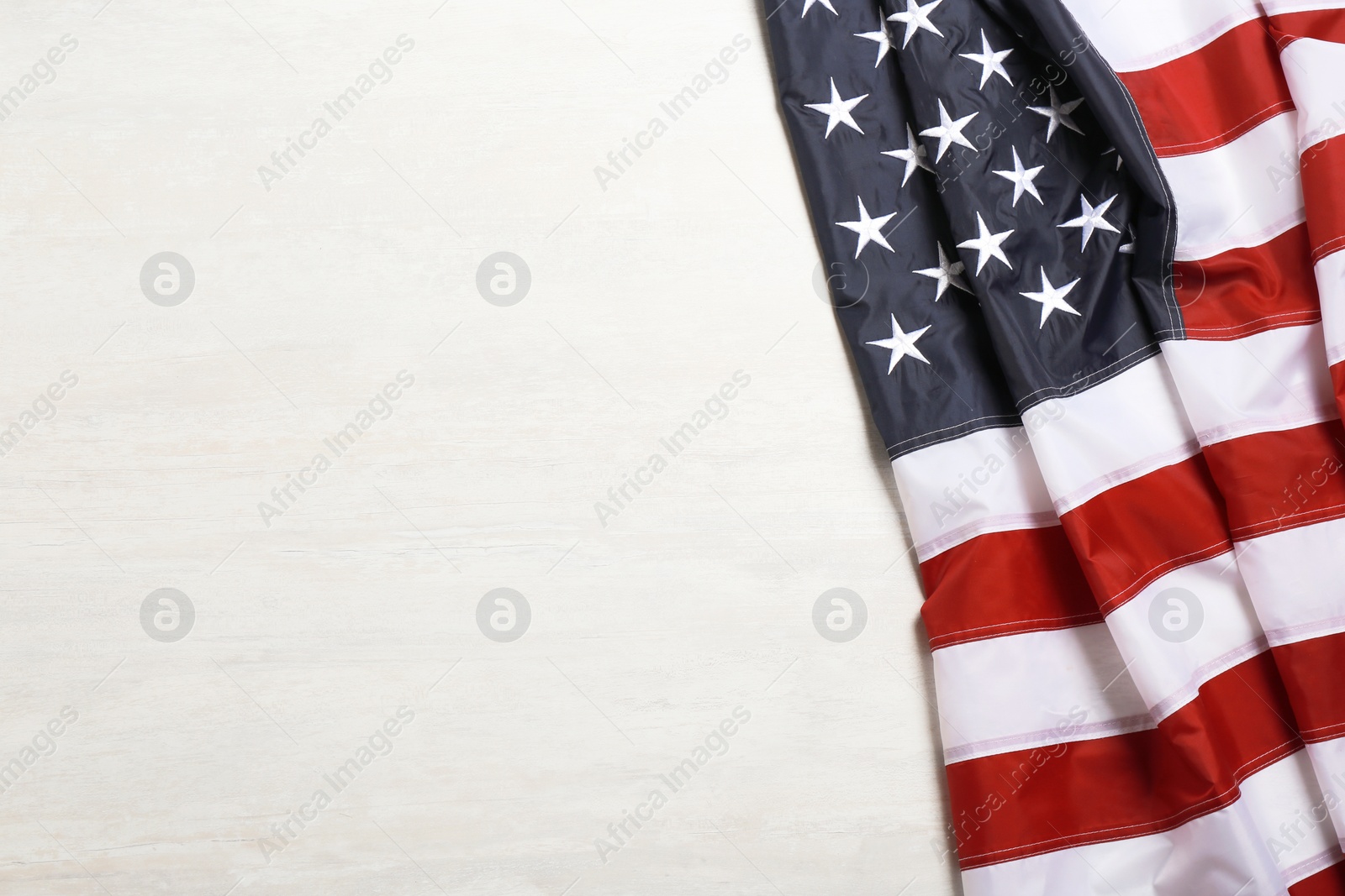 Photo of American flag on white wooden background, top view with space for text
