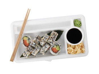 Photo of Food delivery. Delicious sushi rolls with soy sauce, ginger, wasabi and chopsticks in plastic container isolated on white, top view