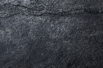 Texture of dark grey stone surface as background, closeup