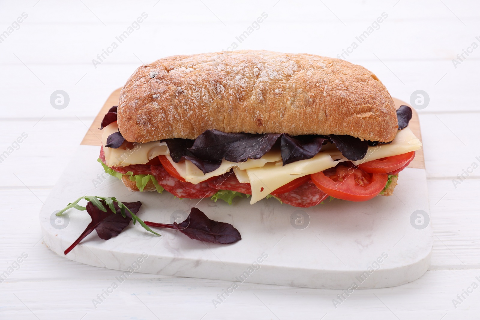 Photo of Delicious sandwich with cheese, salami, tomato on white wooden table