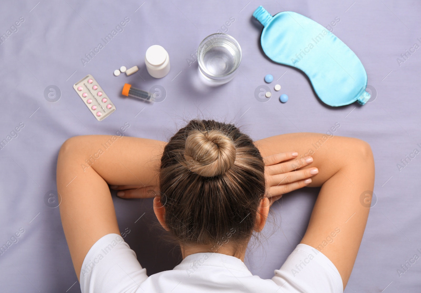 Photo of Woman surrounded by different pills on bedsheet, top view. Insomnia treatment
