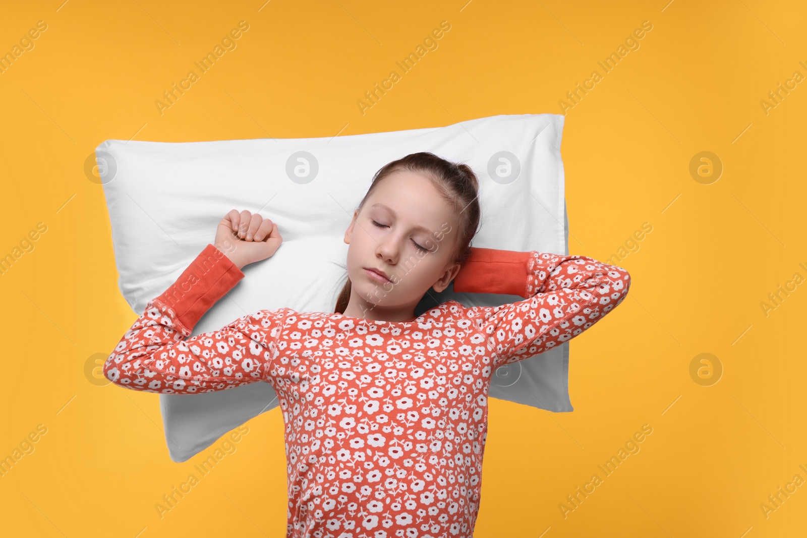Photo of Sleepy girl with pillow on orange background. Insomnia problem