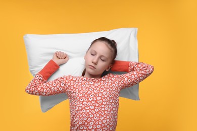Photo of Sleepy girl with pillow on orange background. Insomnia problem