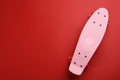 Photo of Skateboard on red background, top view. Space for text