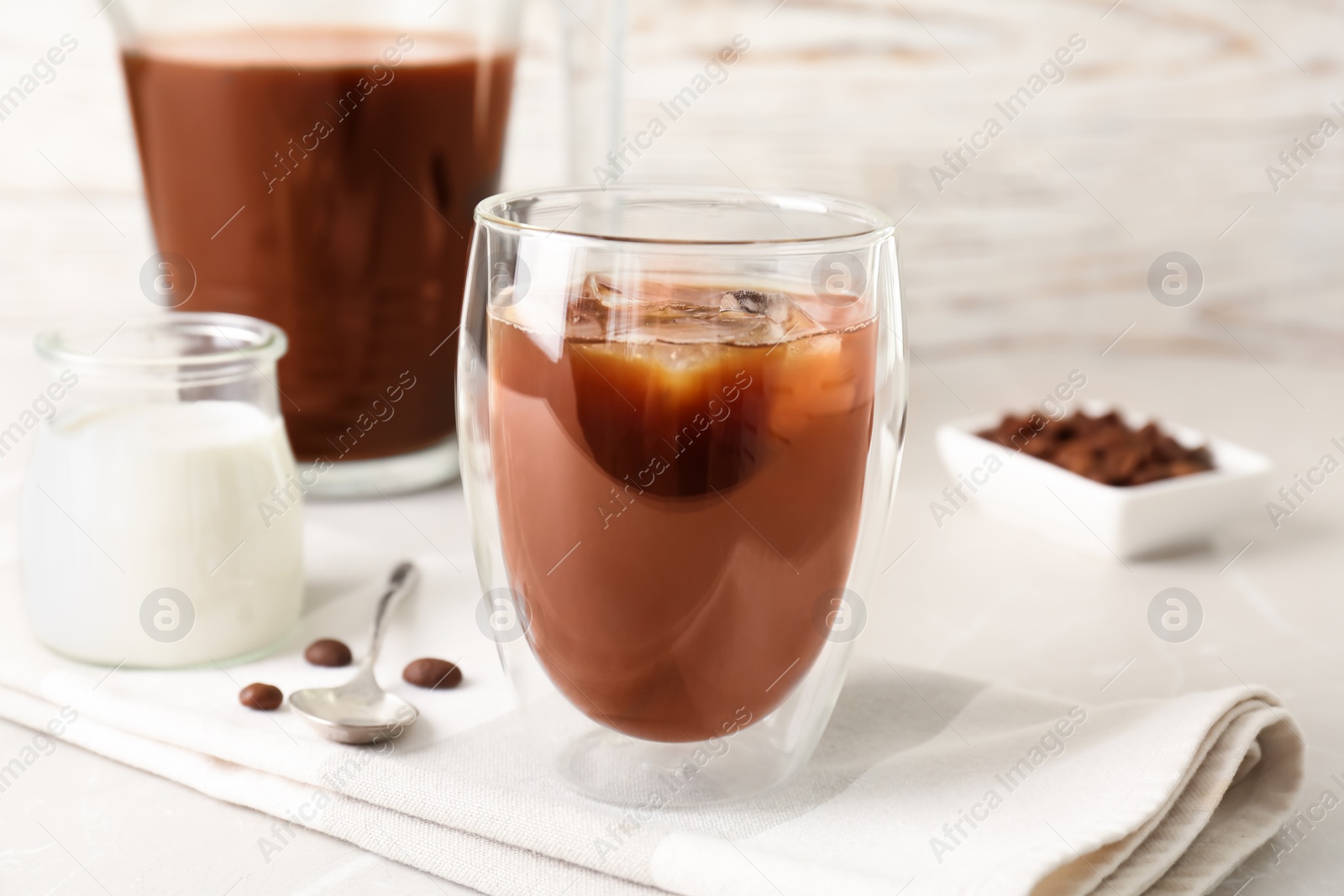 Photo of Glass with cold brew coffee and beans on table