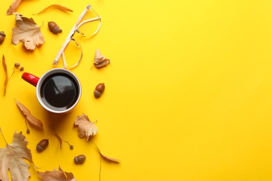 Photo of Flat lay composition with hot drink on yellow background, space for text. Cozy autumn