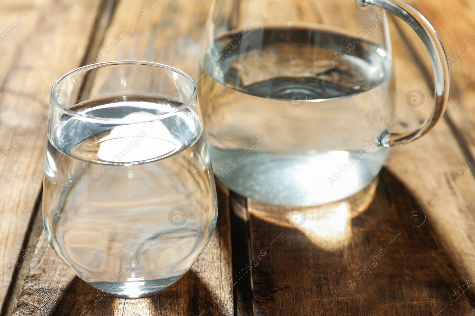 Photo of Glass of water on wooden table, closeup. Refreshing drink