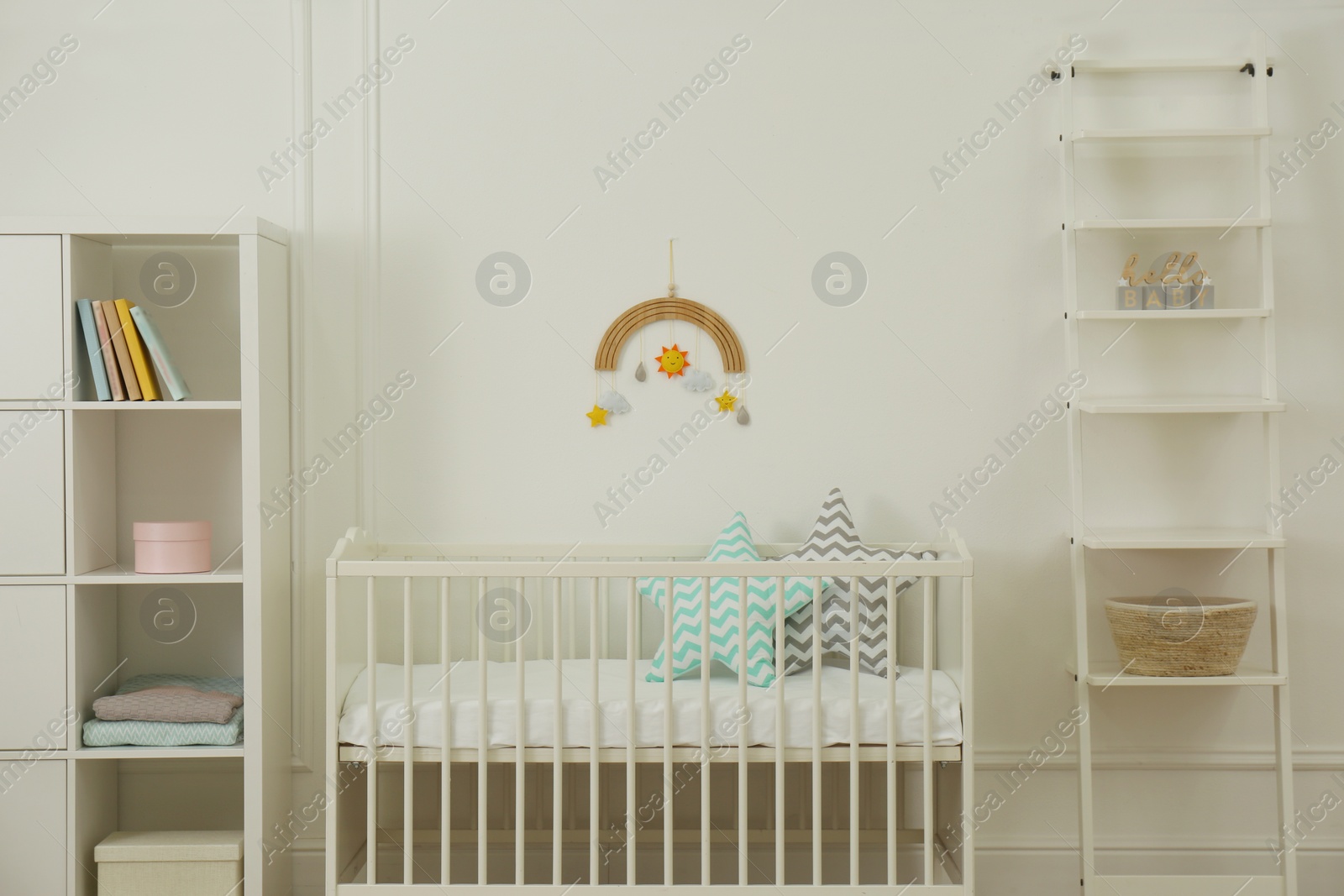 Photo of Cute baby room interior with stylish furniture and pillows