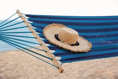 Comfortable hammock with straw hat at seaside. Summer vacation