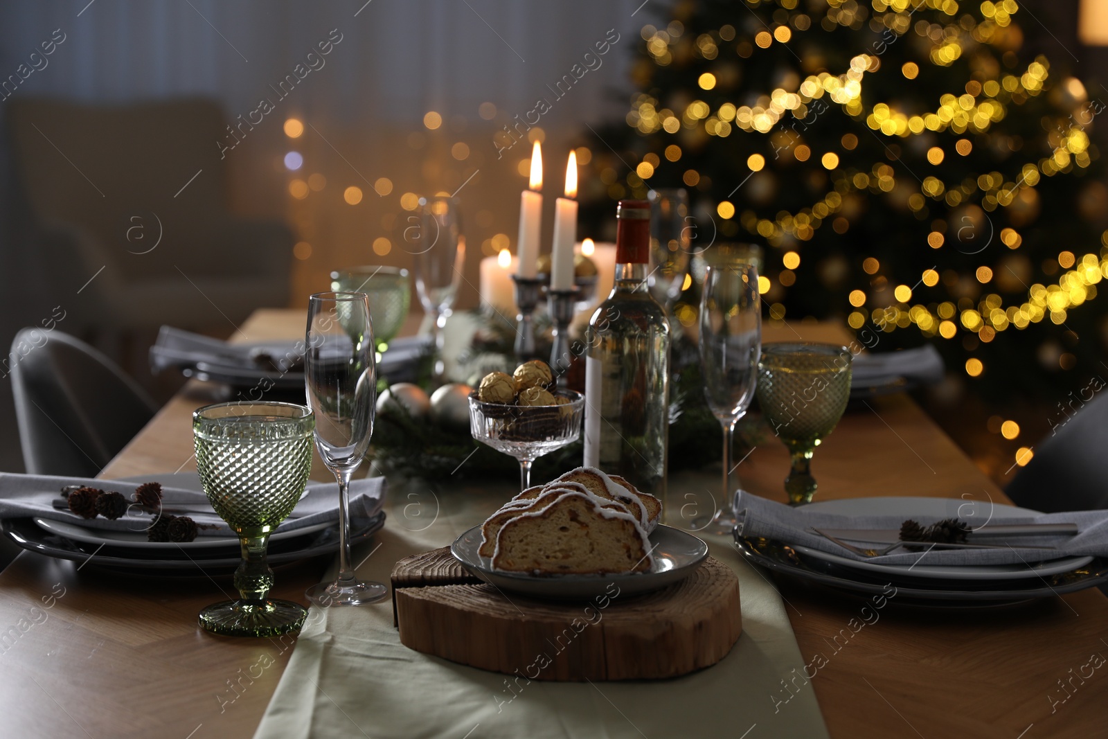 Photo of Christmas table setting with festive decor and dishware in room