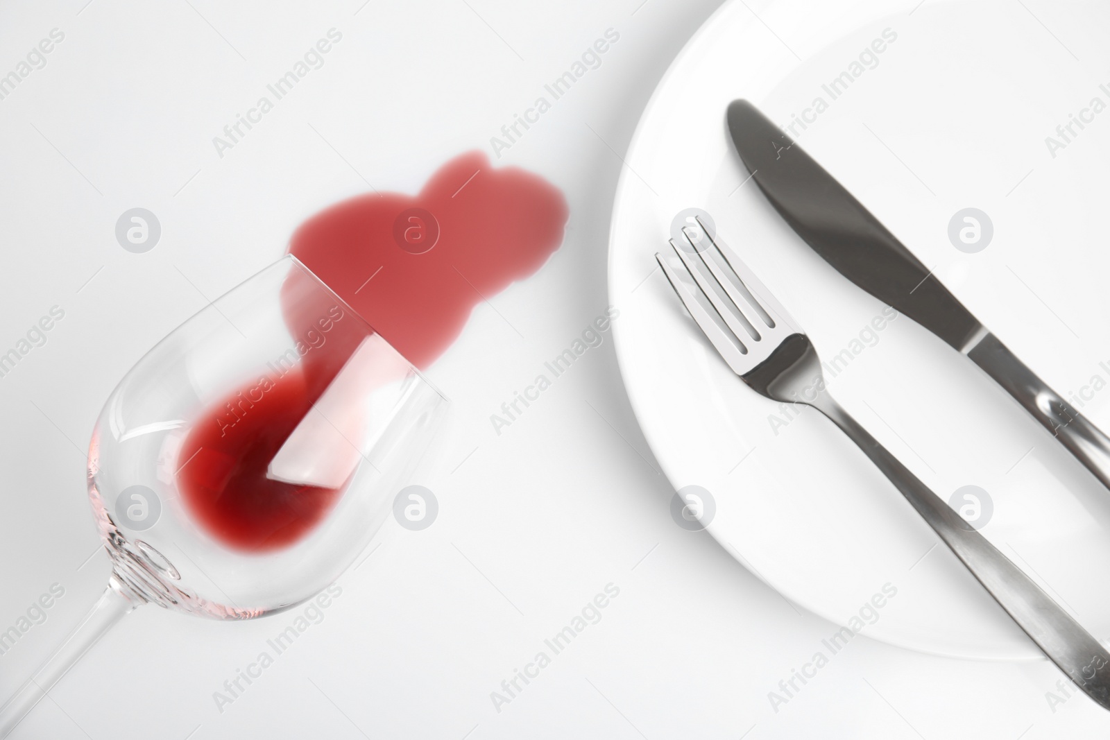 Photo of Composition with spilled wine on white background, top view