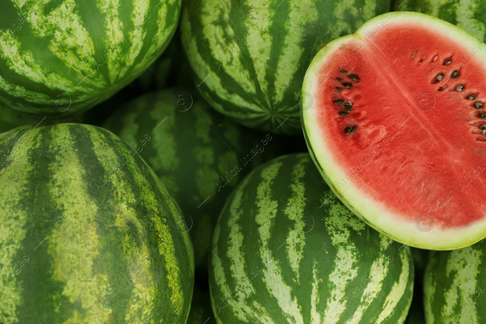 Photo of Delicious whole and cut watermelons as background, closeup