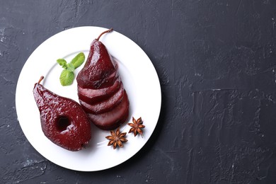Tasty red wine poached pears, mint and anise on black table, top view. Space for text