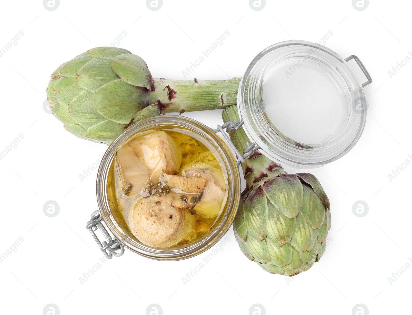 Photo of Open jar of delicious artichokes pickled in olive oil and fresh vegetables on white background, top view