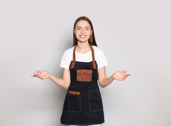 Portrait of happy hairdresser on light background