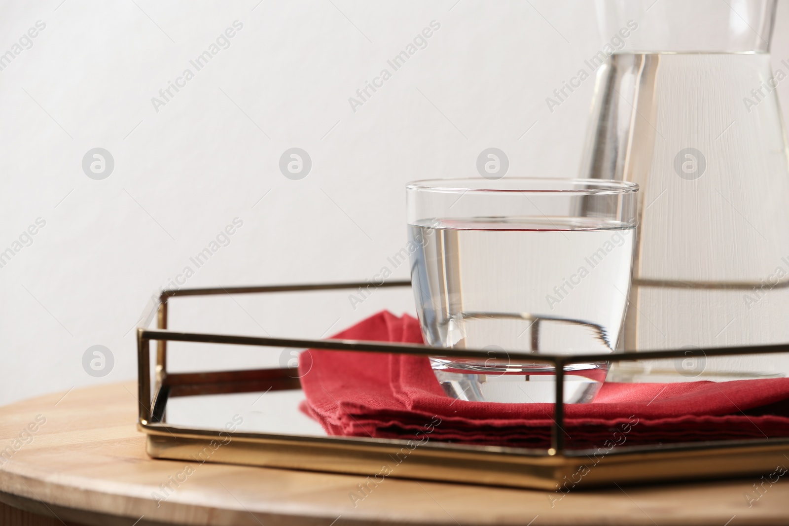 Photo of Carafe and glass with water on table against white background. Space for text