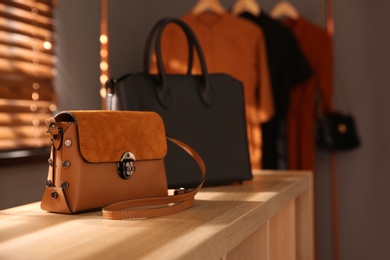 Photo of Stylish woman's bags on shelf in boutique