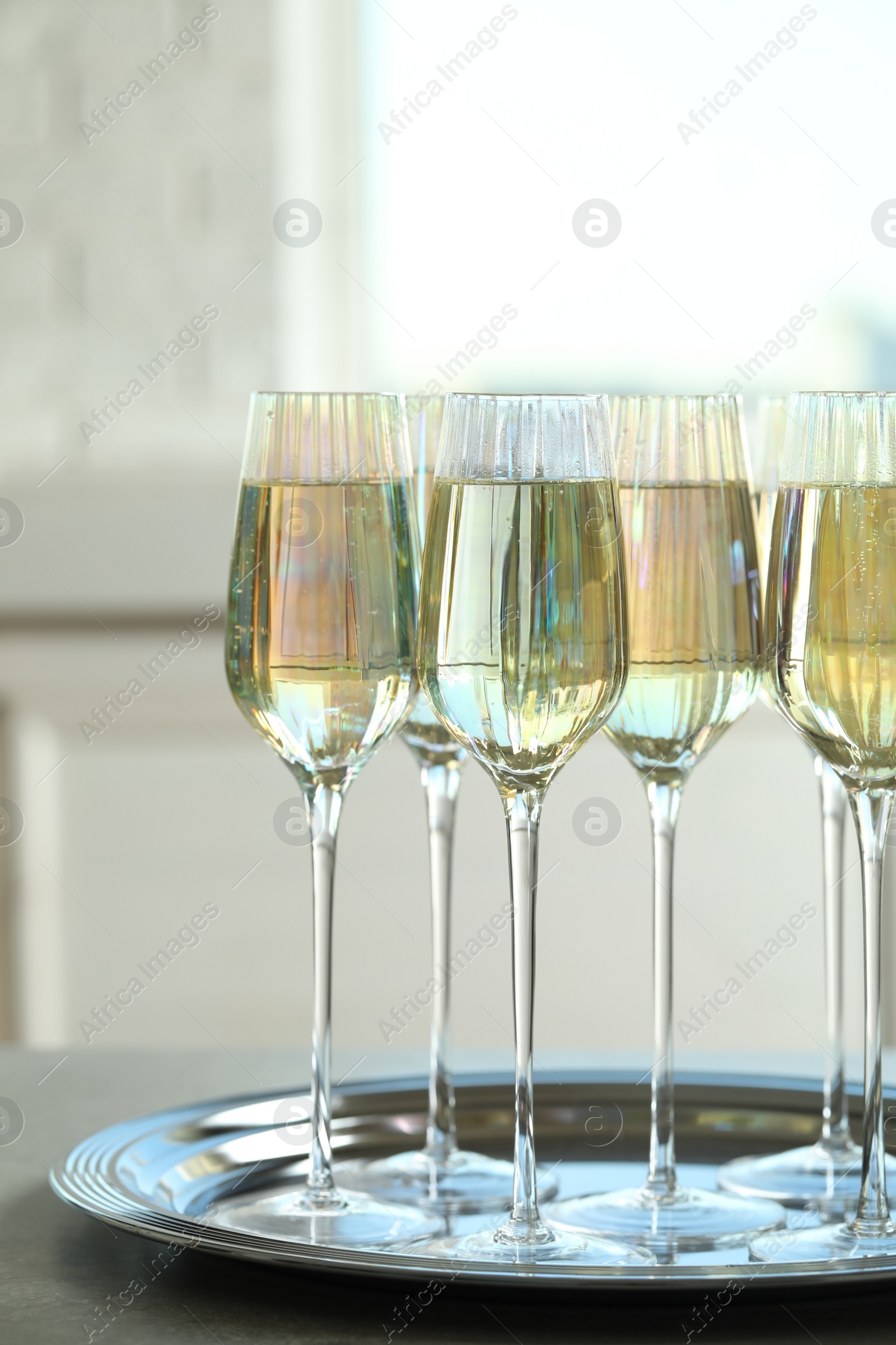 Photo of Glasses of champagne served on grey table