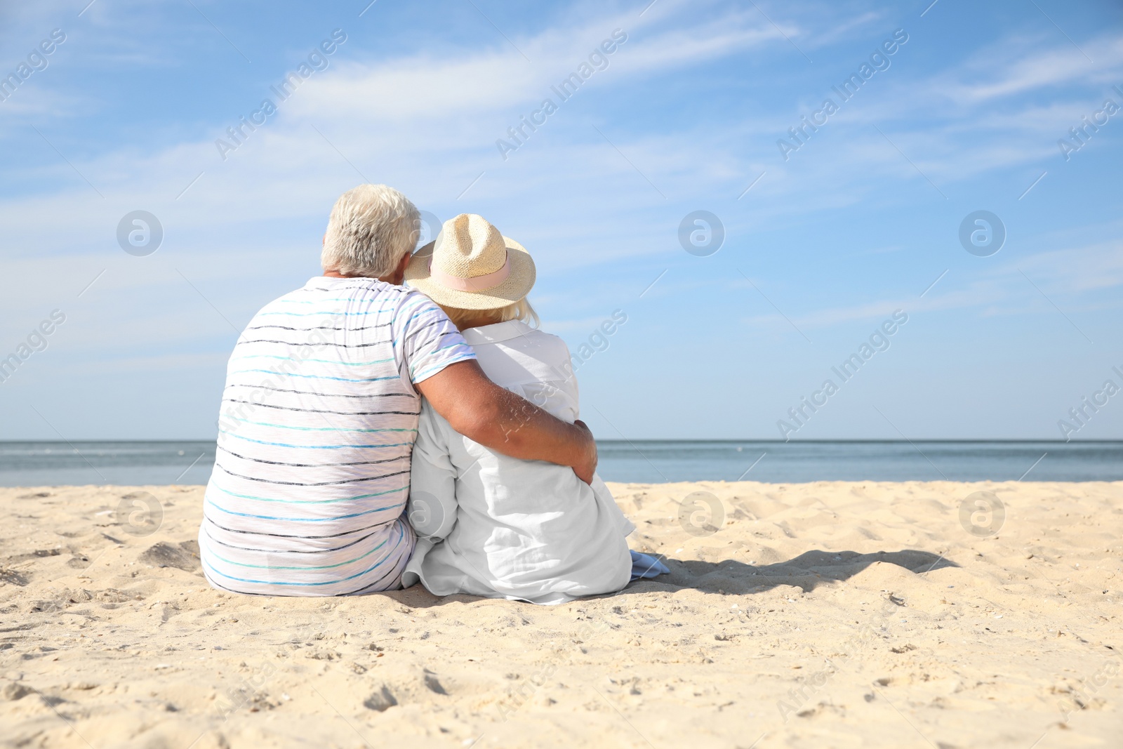 Photo of Mature couple spending time together on sea beach, back view