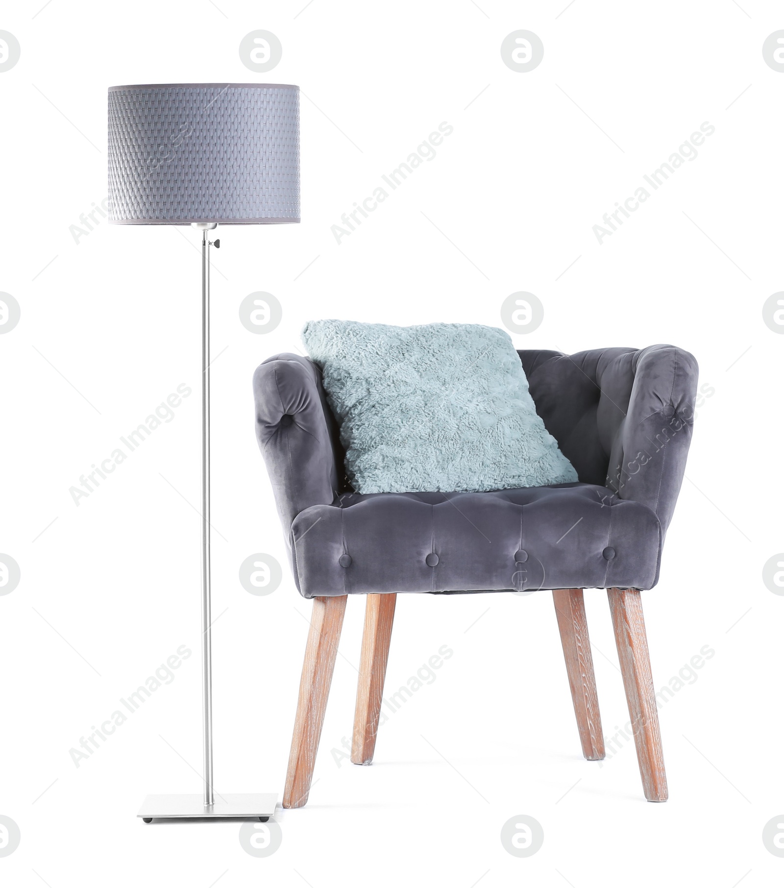 Photo of Comfortable armchair with pillow and lamp on white background