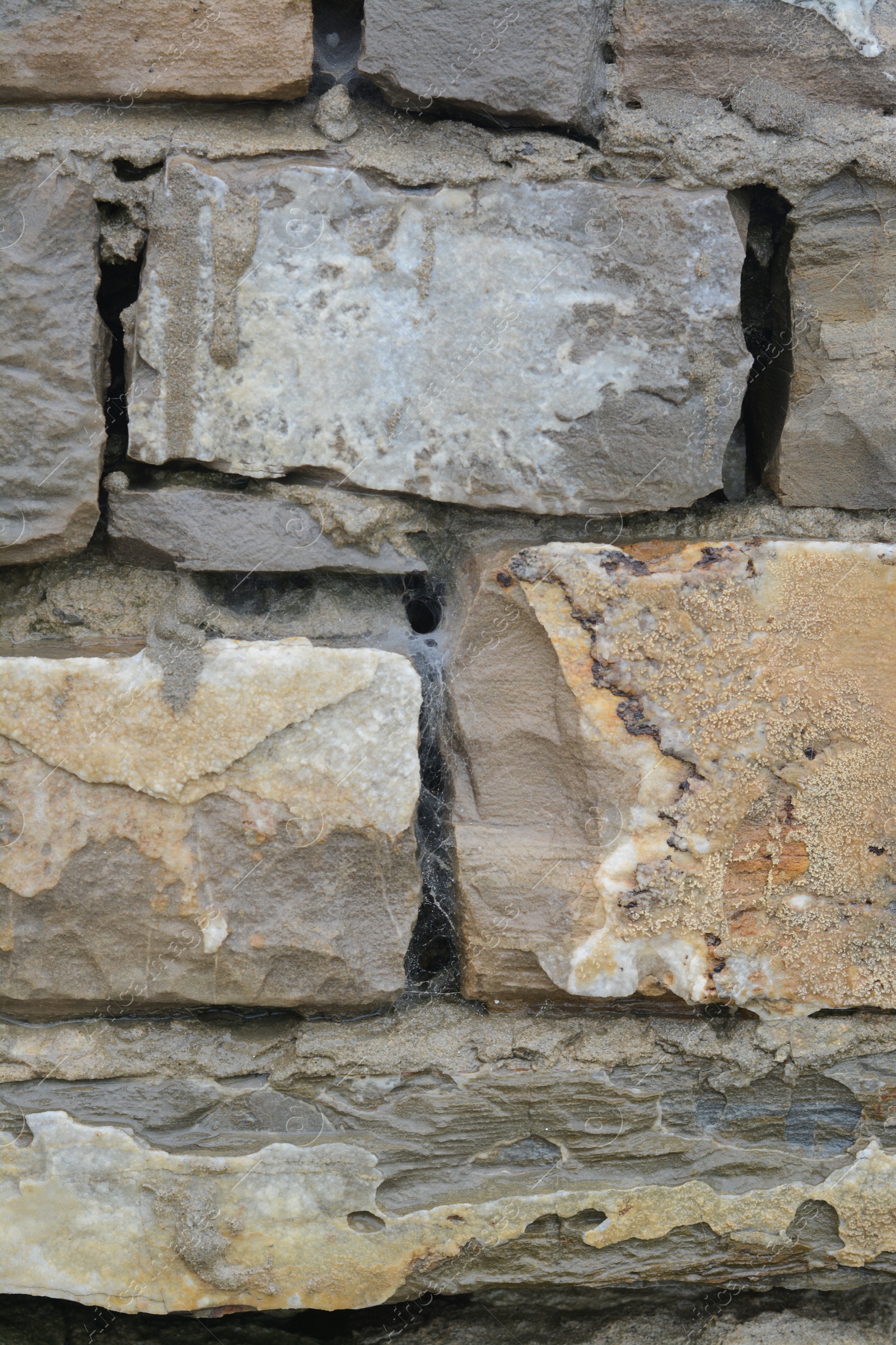 Photo of Wall with different stone fragments as background, closeup