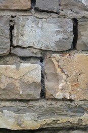 Wall with different stone fragments as background, closeup