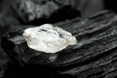 Beautiful shiny diamond on coal, closeup view
