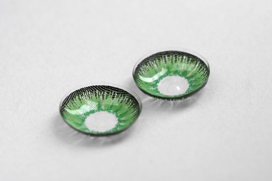 Photo of Two green contact lenses on white background