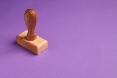One wooden stamp tool on purple background. Space for text