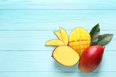 Flat lay composition with mango on color wooden background. Space for text