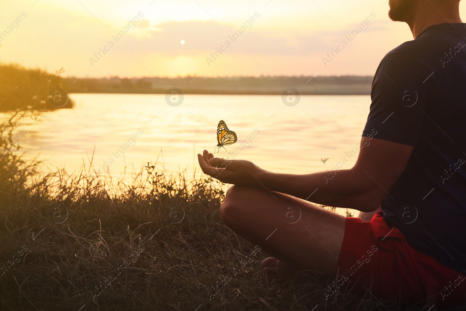 Image of Man meditating near river at sunset, closeup. Space for text