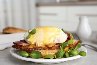 Photo of Delicious egg Benedict with sprouts served on grey table