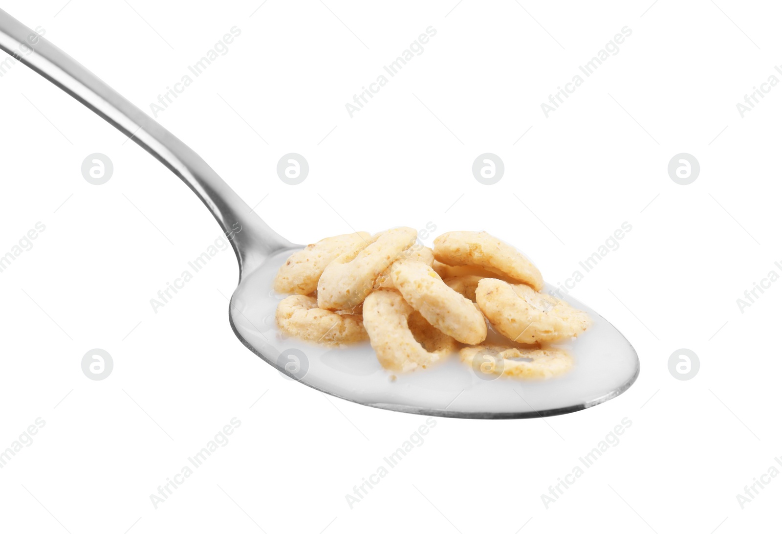 Cereal rings and milk in spoon isolated on white Photo of Cereal rings and milk in spoon isolated on white