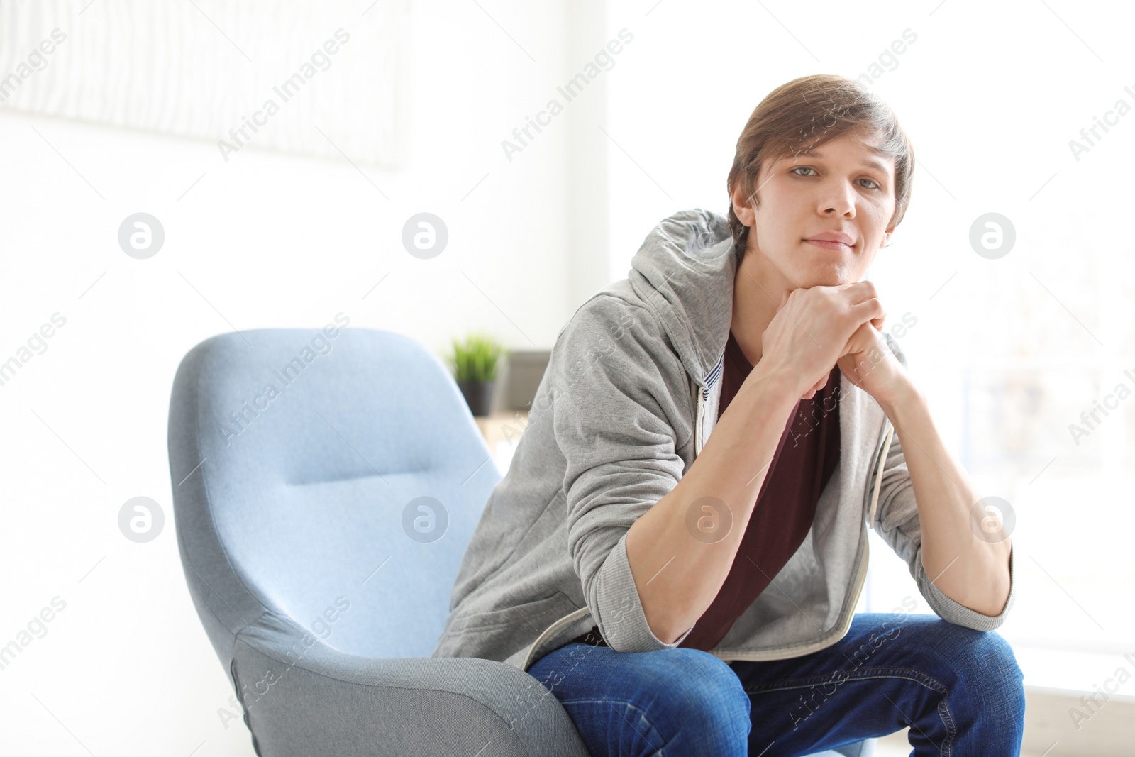 Photo of Portrait of confident young man in armchair