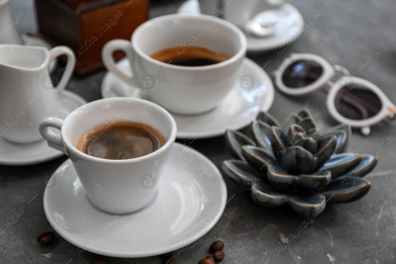 Photo of Cups of fresh aromatic coffee on grey background