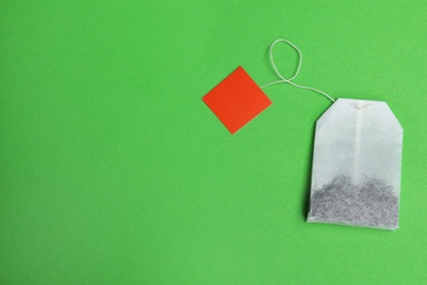 Tea bag on color background, top view with space for text