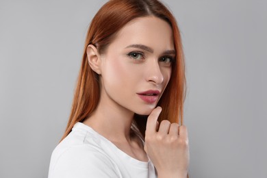 Portrait of beautiful young woman on light gray background