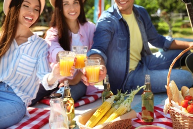 Photo of Young people enjoying picnic in park on summer day, closeup