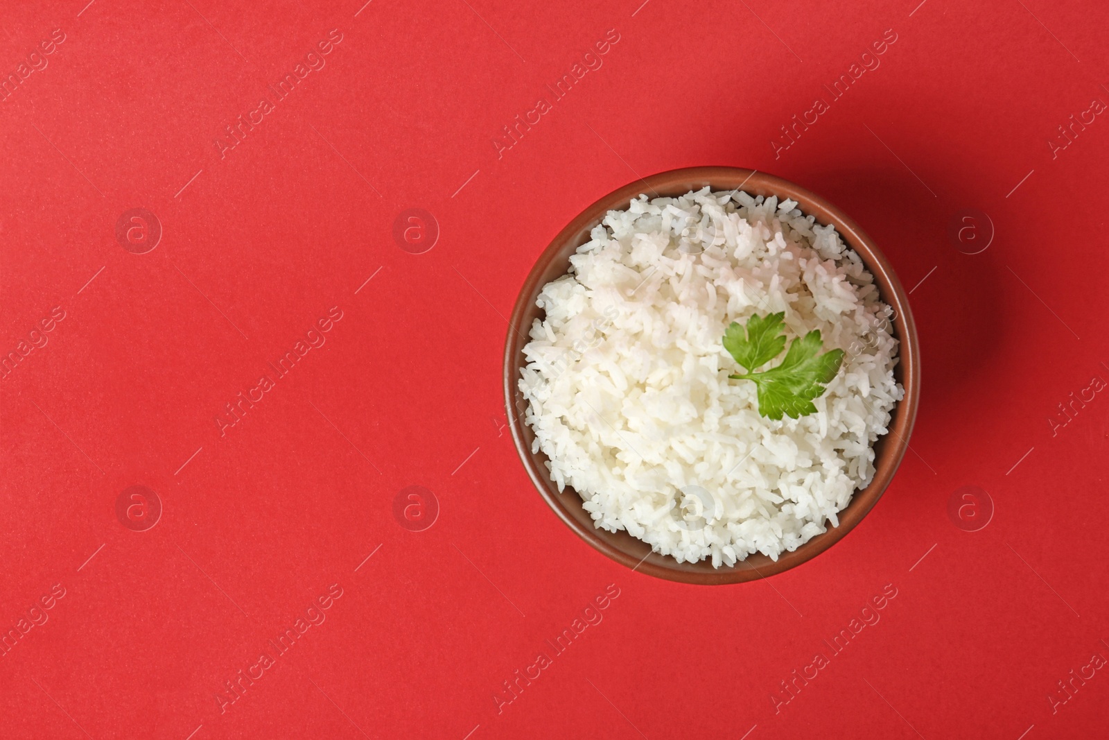 Photo of Bowl of boiled rice on color background, top view with space for text