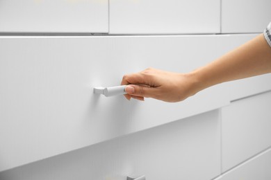 Woman opening drawer at home, closeup view