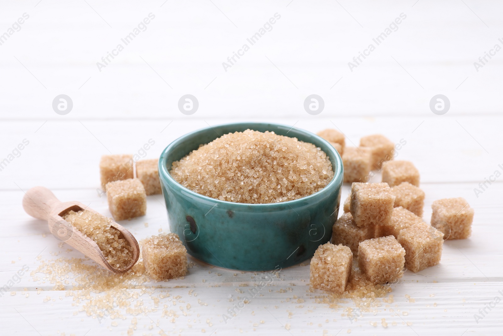 Photo of Different types of brown sugar on white wooden table