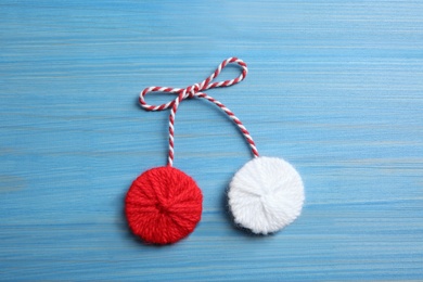 Traditional martisor on blue wooden background, top view. Beginning of spring celebration