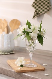 Photo of Beautiful jasmine flowers on wooden table indoors