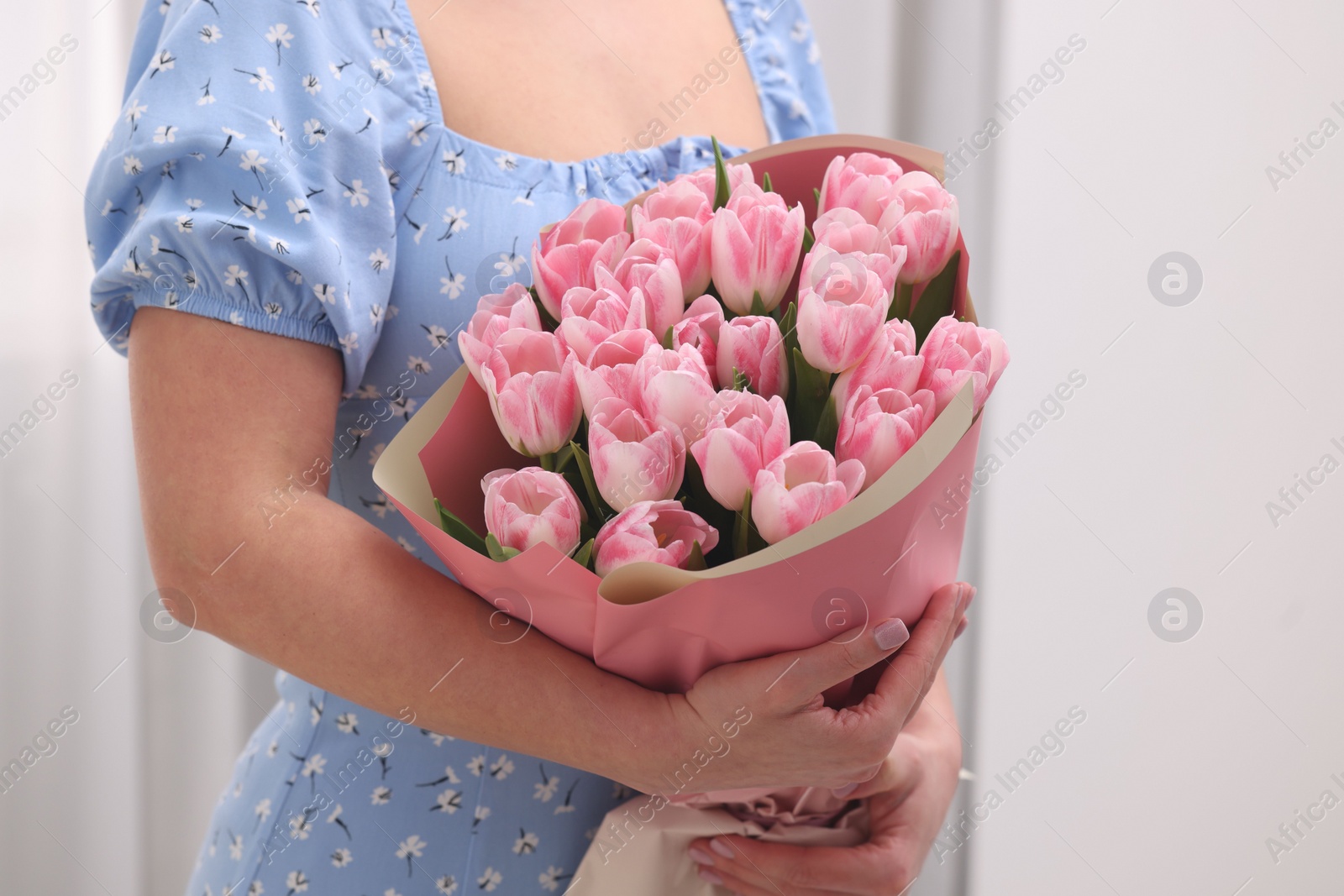 Photo of Woman with bouquet of beautiful fresh tulips on blurred background, closeup