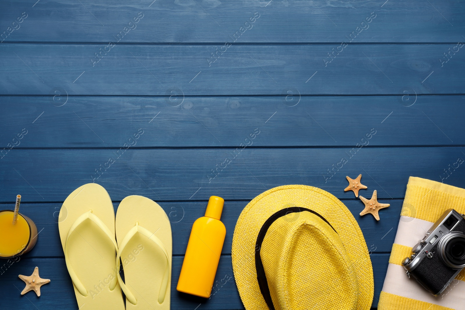 Photo of Flat lay composition with different beach objects on blue wooden background, space for text