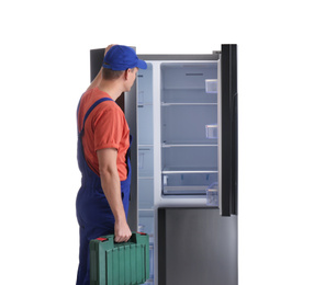 Male technician with tool box near refrigerator on white background