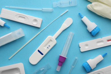 Photo of Disposable express test kits on light blue background, flat lay